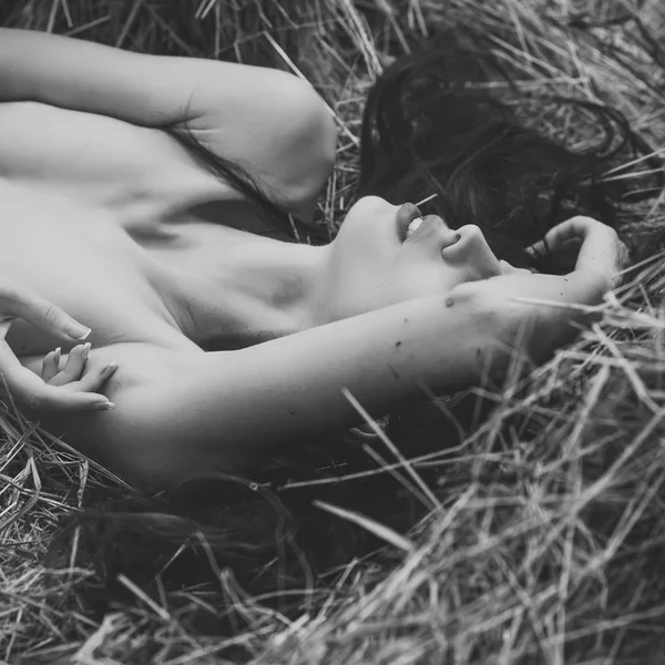 Smyslná žena tělo. Módní model leží na slámě. — Stock fotografie