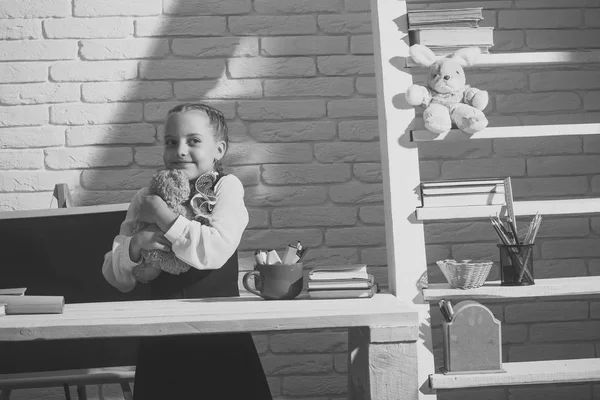 Dětství. Kluk v učebně na pozadí bílá cihlová zeď — Stock fotografie