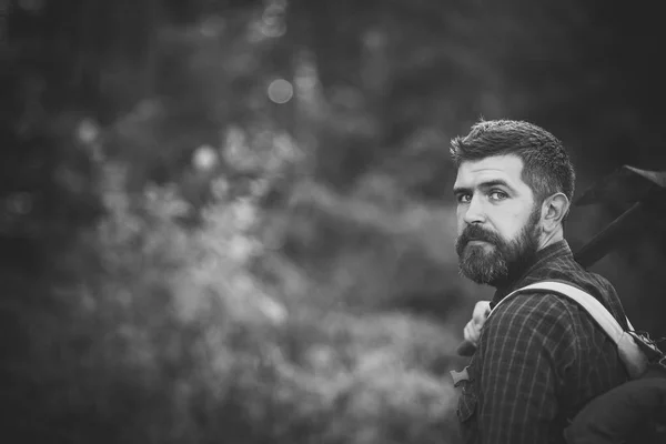 Un hombre elegante de traje. Hombre excursionista mantenga hacha y mochila en el día de verano —  Fotos de Stock