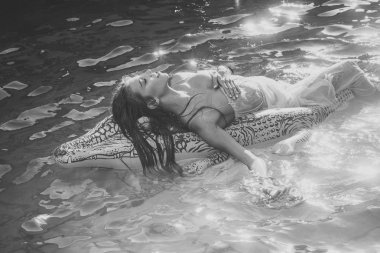 şişme timsah ve kadın havuzda. suda kadınla şişme yatak.