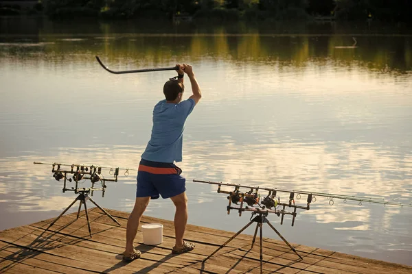 Rybář přilákat ryby s návnada do řeky nebo jezera — Stock fotografie