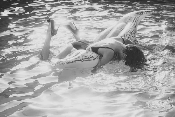 Mulher sensual. mulher morena na praia com crocodilo grande inflável no mar azul transparente. Vista aérea da senhora relaxante no colchão flutuante — Fotografia de Stock