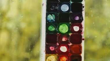 suluboya boyar. Yeşil parıltı penceresindeki su damlaları