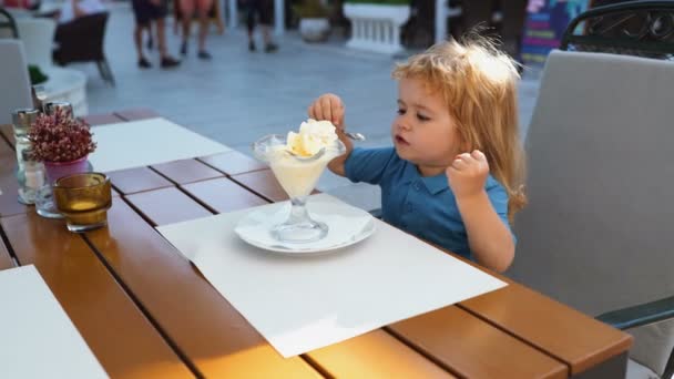 Kind Kindheit Kinder Glückskonzept. süßer Kleinkind Junge isst Eis. — Stockvideo