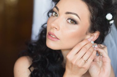 Tatil ve parti hazırlığı. Şehvetli kadın düzeltme küpe. Şık saçlı esmer kadın. Glamour görünüm ve makyaj güzellik kız. Takı ile moda modeli