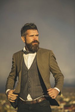 Sakal ve bıyık bulutlu gökyüzü üzerinde olan adam. Hiking, papyon ile klasik paltolu adam