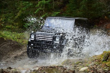 Orman Offroad yarış. Dere ile yolda yarış araba. Extreme sürüş, meydan okuma ve 4 x 4 araç konsepti. SUV veya offroad araba siyah renk geçişi su akışı.