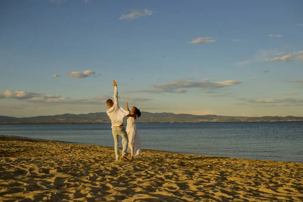 Lune de miel, concept de mariage. Homme et femme dansant, couple heureux en vacances. Couple amoureux courant sur la plage, au bord de la mer. Couple amoureux marchant, s'amusant, fond de mer et d'horizon . — Photo