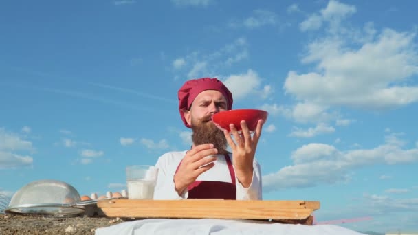 Bäcker mit einer Vielzahl von gesunden und leckeren frisch gebackenen Brot und Gebäck. lächelnder Bäcker, der Mehl einschenkt. fröhliche junge Bäckerin. Bäckerhände kneten Teig in Mehl auf Tisch. — Stockvideo