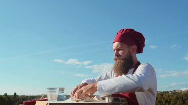 Skäggiga baker. Baker matlagning utanför. Eco bageri. Bagare bakar ett färskt bröd — Stockvideo