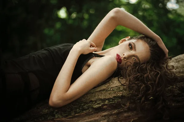 Gesicht Mädchen für Magazin-Cover. Mädchengesicht Porträt in Ihrer Werbung. Frau mit langen brünetten Haaren entspannen auf Baum in der Natur. Frau mit lockiger Frisur im Sommer. Haarpflege, Therapie und Behandlung — Stockfoto