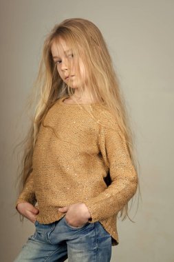 Yüz moda küçük kız ya da çocuk web sitenizde. Gri arka plan üzerinde bir kot elbise giyen küçük kız çocuk moda. Çocukluk.