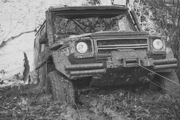 SUV is pulled out from puddle of mud by car winch. — Stock Photo, Image