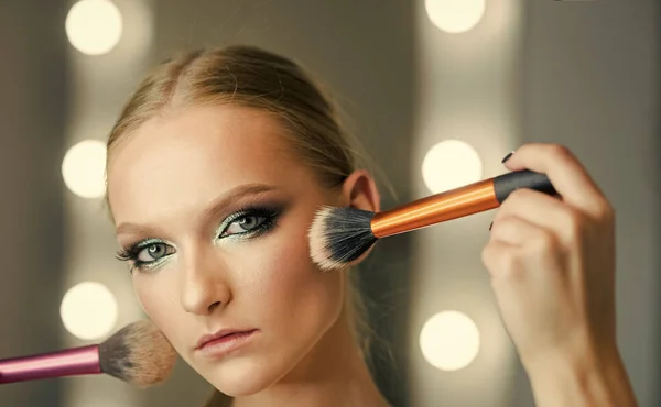 Visage model with makeup brushes. Visage course for glamour makeup. Sexy woman.