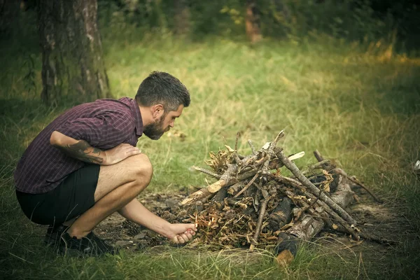 Homme randonneur mis le feu au bois de chauffage pour le feu de joie — Photo