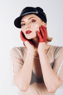 Serin bakmak moda makyaj ile seksi kızı. Deri şapkalı kız. Trendy kız rock tarzı. Gri zemin üzerine sarı saçlı rock kadın. Moda model şık bir saç modeli ile.