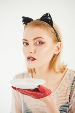 Yavru kedi kulakları ve kırmızı üzerine beyaz izole yoğurt eldivenlerle kız. Seksi kedi kadın yalamak süt plaka. Yiyecek ve içecek. Ekoloji ürün ve heath. Kedi kadın ye ekşi krema. Diyet ve sağlık.