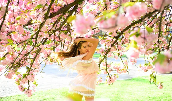 Frühlingsfrau in Kirschblüte. sinnliche Frau bei der Blüte der Sakura-Blume im Frühling. Frauentag mit Mädchen in rosa Kirschblüte. Sakura Blume Schönheit in der Natur. Hautpflege und Sommerkonzept — Stockfoto