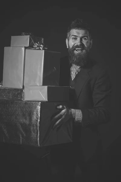 Gits für alle. Mann oder Geschäftsmann hält Stapel von Geschenken auf schwarzem Hintergrund. — Stockfoto
