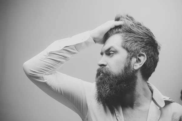 Un salon de coiffure. Coiffure. Concept coiffeur ou salon de coiffure. Macho sur le visage strict, porte une chemise déboutonnée. Homme à longue barbe, moustache et cheveux élégants, fond clair. Guy à la coiffure moderne — Photo