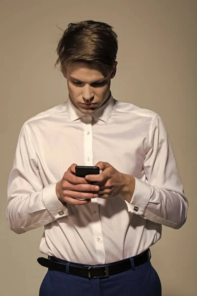 Uomo d'affari. Testo dell'uomo d'affari sul cellulare su sfondo grigio — Foto Stock