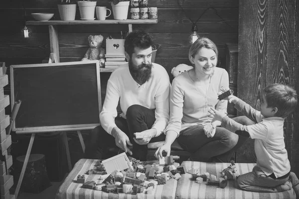 Kinderbetreuung. Vorschulerziehung.Familie auf geschäftigen Gesicht verbringen Zeit zusammen im Spielzimmer. Kinder mit Eltern spielen mit Plastikklötzen, bauen eine Konstruktion. Lernspielkonzept. Vater, Mutter und niedlich — Stockfoto