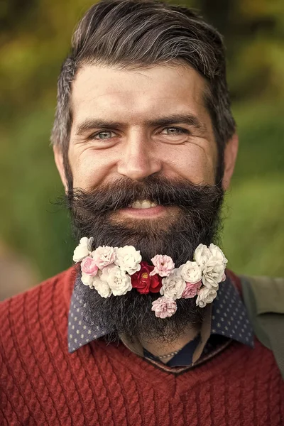 Ευτυχισμένος γενειοφόρος άνδρας με λουλούδια. Ο άνθρωπος με τα λουλούδια στα γένια — Φωτογραφία Αρχείου
