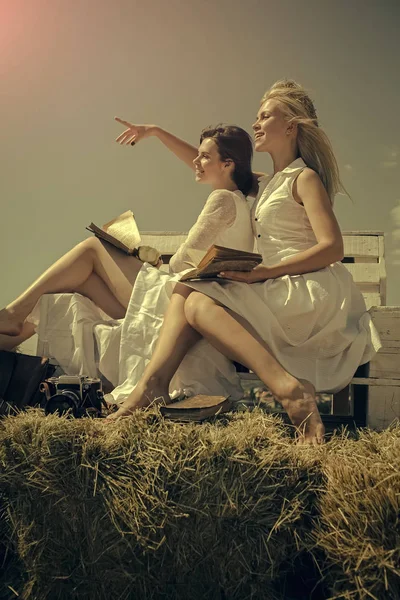 Glad lesbisk par. Kvinnor i halm kransar och vita klänningar — Stockfoto