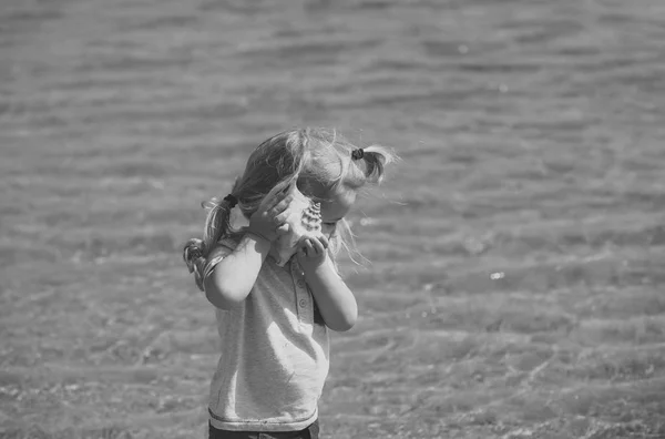 Vacances d'enfants. Garçon écouter coquille sur mer plage — Photo