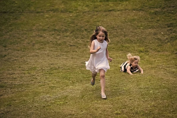 Dla dzieci gry - happy gra. Dzieci uruchomić i spadnie na zielonej trawie na letni dzień — Zdjęcie stockowe