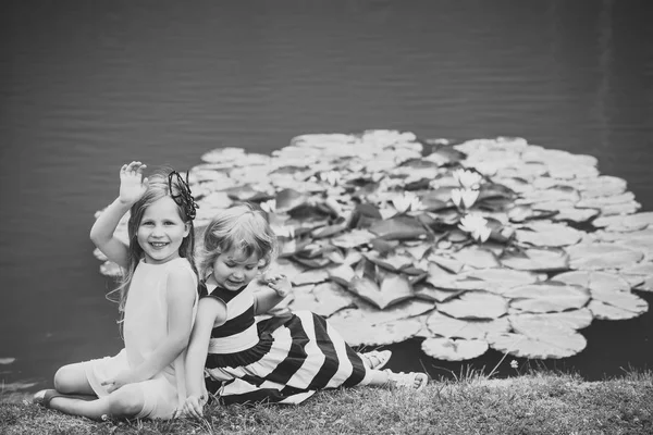 Amistad infantil. Niños feliz sonrisa en verde lago paisaje —  Fotos de Stock