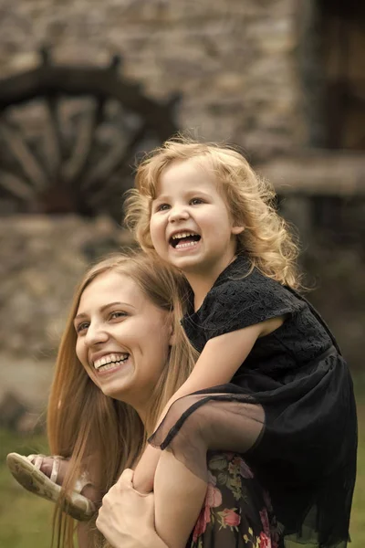 Bonne famille. fille enfant sourire sur femme épaules — Photo