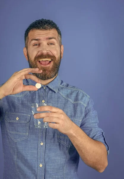 La puissance des hommes. Homme avec barbe tenir verre d'eau sur fond bleu, maux de tête . — Photo