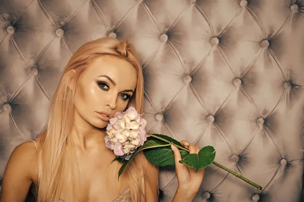 Hudvård. Sensuell kvinna med makeup ansikte, långa blonda hår, hortensia blomma — Stockfoto