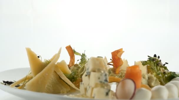 Assiette de repas au fromage mélangé de différentes variétés de fromage décoré avec des olives noix laitue persil . — Video