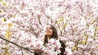 Bahar, bir çiçeklenme tree yakınındaki kız.