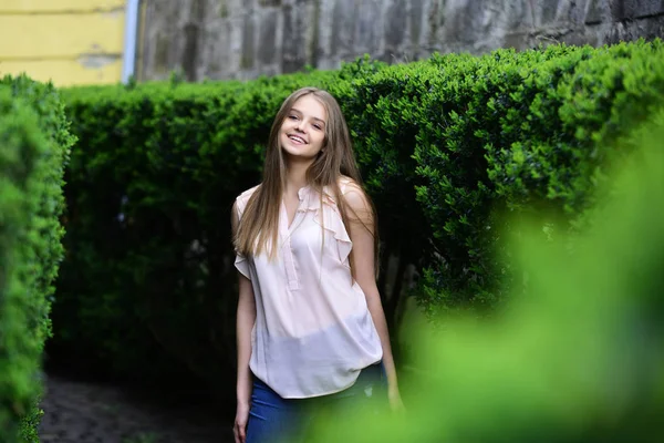 Modelo sensual com maquiagem após cabeleireiro. olhar de menina perto de plantas verdes. menina em roupas casuais ao ar livre. Verão ou primavera moda e beleza. Mulher sexy com cabelos longos no parque de verão — Fotografia de Stock