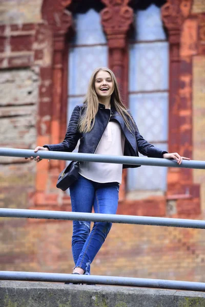 Olhar de menina perto da janela. menina em roupas casuais ao ar livre no belo edifício. Mulher sexy com cabelo comprido. moda e beleza. modelo sensual com maquiagem. conceito de arquitetura e estrutura — Fotografia de Stock