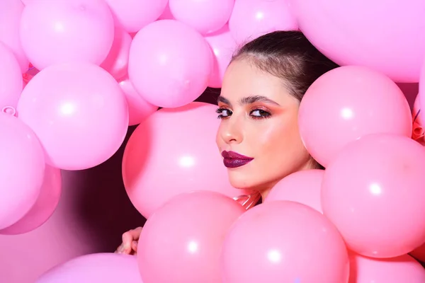 Birthday decor and celebration. Retro girl with stylish makeup and hair. girl dreaming in punchy pastels trend. Fashion woman with many pink air balloons. Balloon party on pink studio background