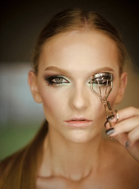 Kaş düzeltme. Kadın kirpik kıvırma maşaları, closeup ile düzeltir.