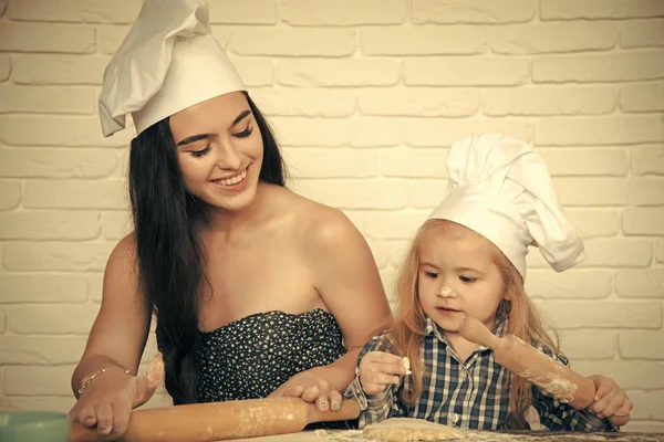 Assistente de mães. Mulher e menino em chapéus chef — Fotografia de Stock