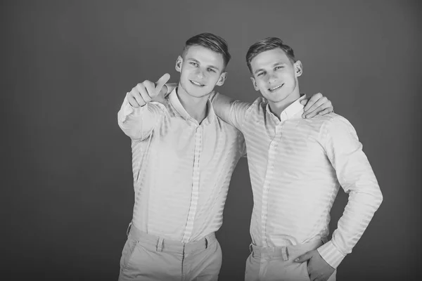 Junggesellen. zwei Brüder lächeln und zeigen mit dem Finger — Stockfoto