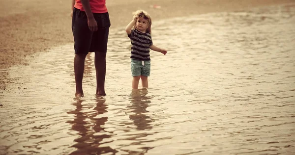 Niño en el mar. Niño bajo supervisión adulta caminar en el agua en la playa de mar — Foto de Stock