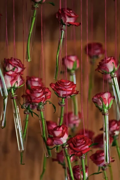 Samenstelling van de bloem. Ingerichte flessen met roze bloemen hangen van bindgaren — Stockfoto