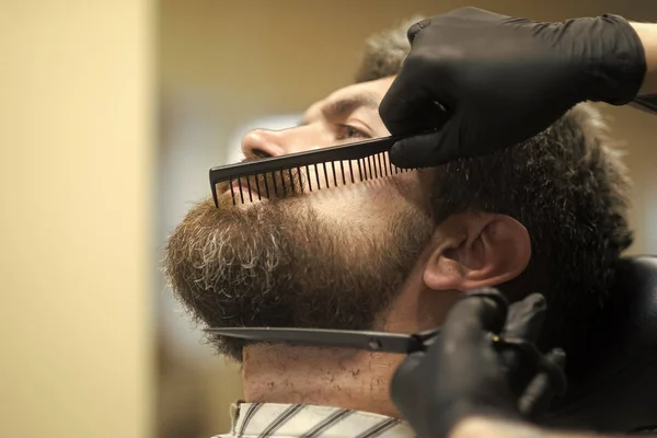 Hipster with serious face in barbershop, new technology.