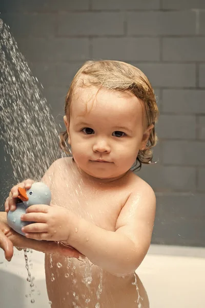 Glückliches Kind, das Spaß hat. Kind mit Entlein in der Dusche — Stockfoto