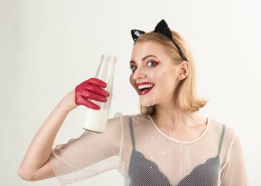 Güzel model siyah kedi kostüm süt cam şişe içme portresi.