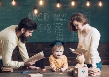 Baba ve oğulları, arka plan kara tahta öğretim kitap, okuma anne. Aile eğitimi oğulları hakkında umurunda değil. Lisansüstü şapkalı çocuk çocuk dinleme öyküleri seviyor. Evde eğitim kavramı.
