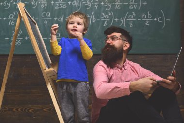 İş Öğretmen sınıfta işyerinde dizüstü bilgisayarda yazarak. İyi öğretmen meydan okuyor ve ilham veriyor. okul öncesi çocuğa özel ders veren öğretmen.