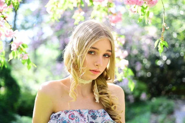 Spring beauty meisje met lange rode haren buiten waait. Bloeiende sakura boom. Romantische jonge vrouw portret. — Stockfoto